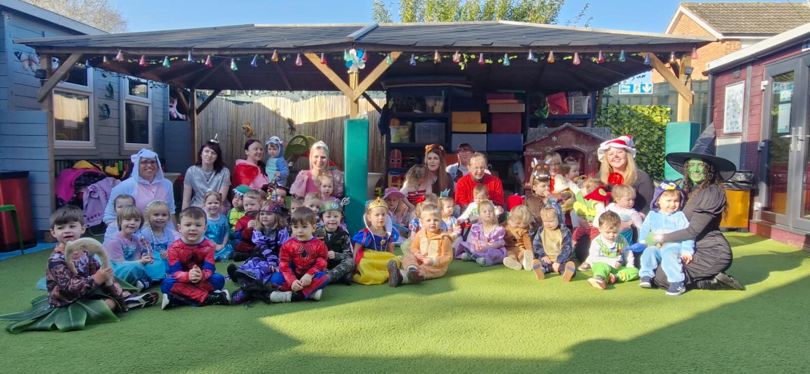 Children and staff dressed up together outdoors